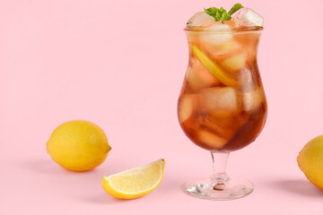 Glass of Long Island iced tea cocktail with mint and lemons on pink background