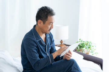 寝室で起きるミドルの男性