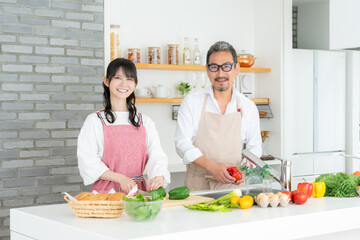 キッチンで料理をするミドルの夫婦