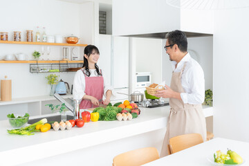 キッチンで料理をするミドルの夫婦