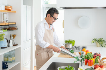 キッチンで料理をするミドルの夫婦