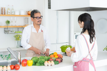 キッチンで料理をするミドルの夫婦