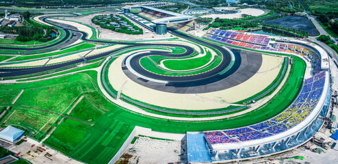 Aerial view of a world class international motorsport circuit with a dynamic track layout and large grandstands.