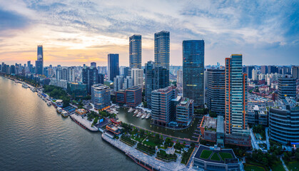 Panorama of modern city waterfront with residential and office towers at sunset.