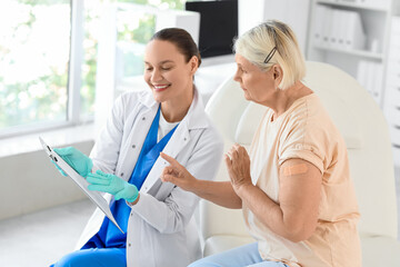 Obraz premium Senior woman with doctor after vaccination in clinic