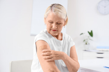 Senior woman with medical patch after vaccination in clinic