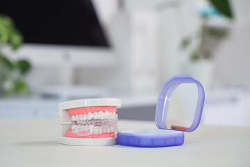 Jaw model with occlusal splint and box in dentist's office, closeup