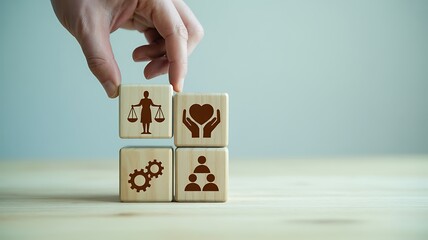 Human hand arranging wooden blocks depicting justice compassion teamwork and collaboration on wooden surface