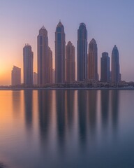 Obraz premium Sunrise over Dubai skyline reflected in calm water