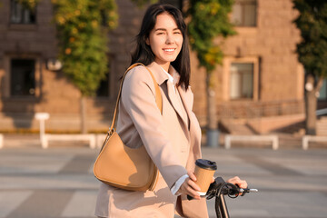 Young businesswoman riding electric scooter on street