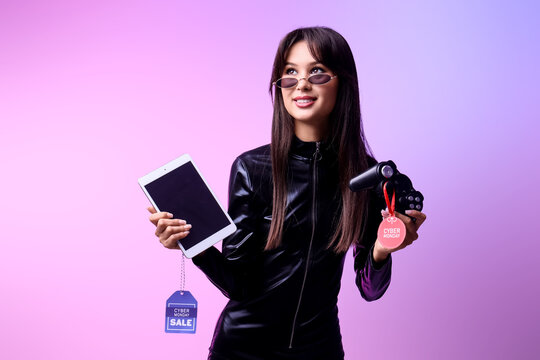 Young woman with tablet computer and game pad on light background. Cyber Monday - Powered by Adobe