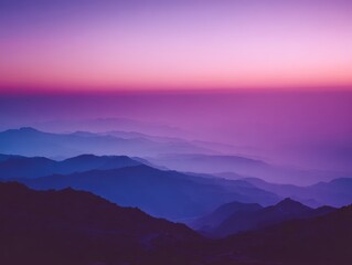 Obraz premium Stunning panoramic view of hazy mountain range illuminated by a dreamy vibrant gradient sunset with purple, pink, and blue hues.