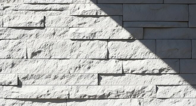 White brick wall with sunlight casting a shadow creating a geometric pattern design effect - Powered by Adobe