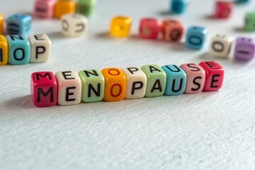 Colorful alphabet beads spelling 'MENOPAUSE' on white background, softly illuminated with gentle lighting, symbolizing women’s health, awareness, life transition, and medical education