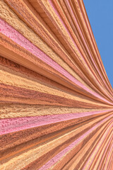 Colorful architectural design features vibrant ridged patterns against a clear blue sky in a modern setting