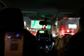 Driving in Bangkok, Thailand at night. Interior view of taxi cab in traffic. Rear view