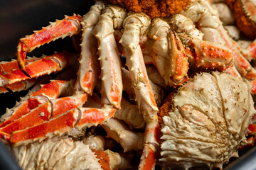Detailed view of freshly cooked king crab legs showing vibrant red and white shells, with sharp textures and natural patterns, highlighting the crustacean's distinctive appearance