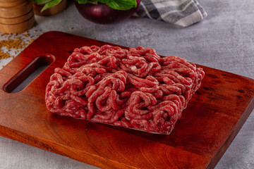 Raw minced beef meat over board