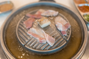 Thai style barbecue or Mookata, raw meat grilled on the stove. Close up