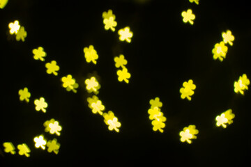 Bright Yellow Flower-Shaped Lights Create a Magical Atmosphere in a Dark Setting During a Festive Evening