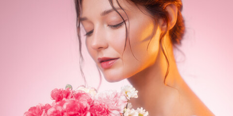 Beautiful Woman With Fresh Flowers In Soft Pink Light