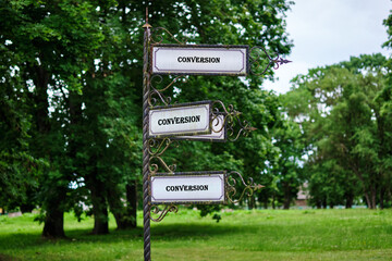 Business ask any questions concept. Copy space. CONVERSION text written on a vintage signpost stands tall in a serene park