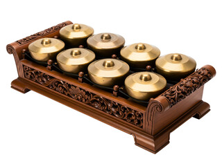 Traditional percussion instrument with brass gongs on a carved frame on a transparent background