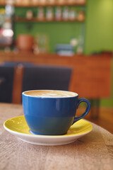 Blue cup on yellow saucer in a cozy cafe setting