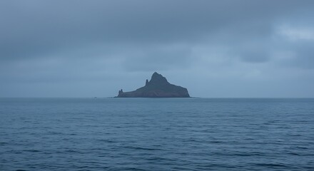 Island silhouette in calm ocean waters under dramatic cloudy sky