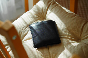 Wallet resting on a cushion in bright sunlight. lost wallet concept 