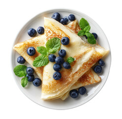 Stack of golden crepes topped with blueberries and mint