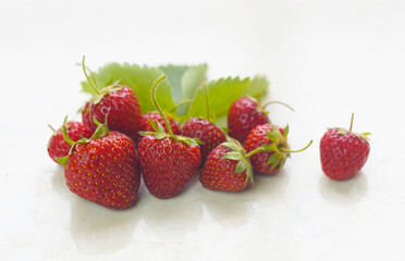 Strawberries are standing on a white marble table.