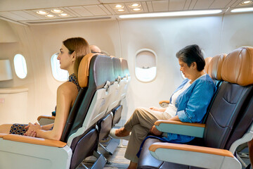 Inside of aircraft seat room with passengers sitting for travel by airline service.