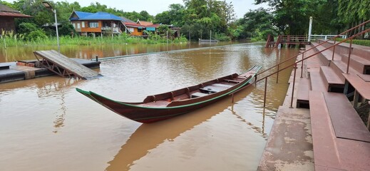 Wooden house , boat and tree near the river. Ayutthaya, Thailand.