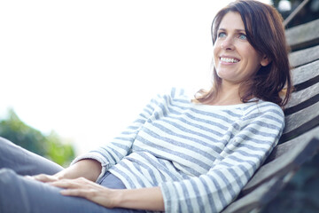 Happy, thinking and woman relax in backyard with vision, calm morning and remember memory on swing. Smile, mature person and rest with reflection, fresh air and wellness for weekend break at house