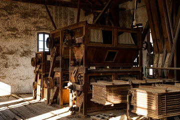 Vintage machinery displayed in a rustic warehouse during daylight