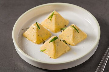 Four pyramid shaped herb cheese bites served with chives