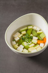 Italian minestrone soup with diced vegetables in a clear broth