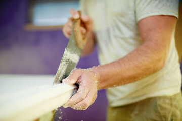 Hands, person and cutting surfboard with tools for custom design, shaping guide and repair work. Worker, carving equipment and board for crafting process, diy restoration and manufacturing precision