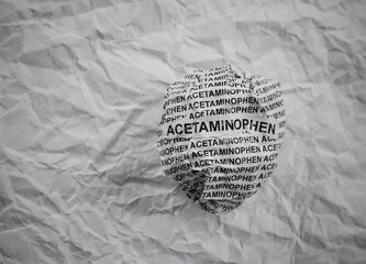 Crumpled paper ball with words Acetaminophen on a crumpled white paper background.