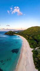 Fototapeta premium Serene coastal panorama a crescent of white sand beach curves gently into turquoise waters, fringed by lush green hills under a tranquil twilight sky