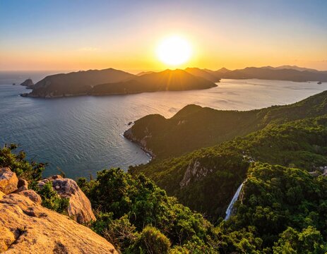 Sunset over a serene coastal landscape, showcasing a cascading waterfall, verdant hills, and a tranquil bay dotted with islands
