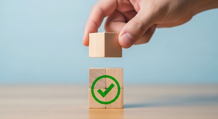 Hand placing wooden block with green checkmark symbol on top of another block