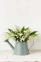 Lily of the valley bouquet in watering can on a white background