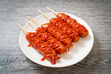 fried sausage skewer with ketchup
