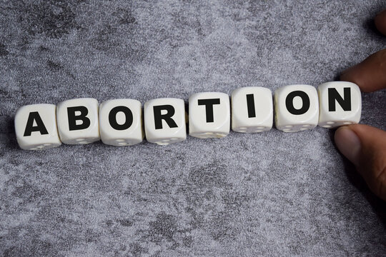Abortion on stacked wooden cubes on the table. Business and finance concept