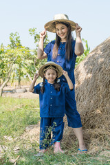 Asian mother and daughter dress up as farmers to do agricultural activities.