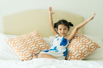 The girl is happy in bed.