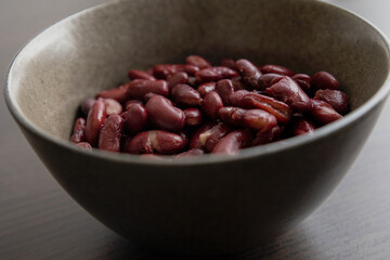Red Beans in Dark Bowl on Moody Black Background Close-Up