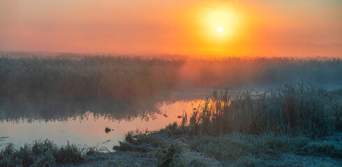 Fototapeta premium A river against the sun. A foggy autumn morning. The first frosts.